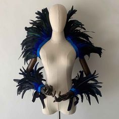 a white mannequin with blue feathers on it