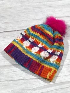 a multicolored knitted hat with a pom - pom on top