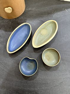 three blue and green bowls sitting on top of a table