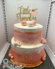 a pink and white cake sitting on top of a table