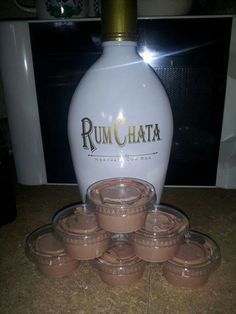 a white bottle sitting on top of a counter next to some brown cups and saucers