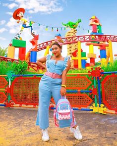 a woman standing in front of an amusement park