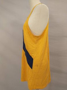 "From the estate of a collegiate crew member this is a 1970's athletic tank top jersey. Could have been for rowing or track, any sport a tank was appropriate for. Color is sunflower yellow - gold with navy blue stripe and lettering. Letters are N 2V, stripe is sewn on. Light/mid weight knit, label missing, likely made in USA. No size marked. Overall condition good, seems to have aged with a very slight diagonal twist. Some light marks on left shoulder and left side back. Has stretch, measurement Cotton Activewear With Three Stripes For Sports Events, Collegiate Sleeveless Tops For Sports Season, Cotton Activewear With Three Stripes For Sports Season, Cotton Activewear With Three Stripes And Crew Neck, Collegiate Sleeveless Tank Top For Sports Events, Cotton Crew Neck Activewear With Three Stripes, Collegiate Sports Tank Top, Sleeveless Team-colored Tops For College, Collegiate Sleeveless Tank Top For Sports