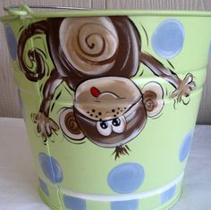 a green bucket with a monkey painted on it