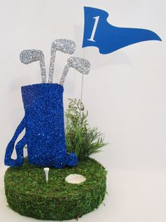 there is a blue vase with golf clubs in it on top of the green grass