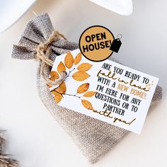 an open house sign on top of a bag