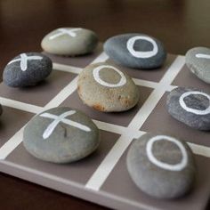 rocks arranged in the shape of crosses on a tic - tac - toe board