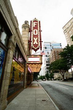 the fox theater sign is hanging on the side of the building next to the street