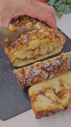 a person is cutting some bread on a board