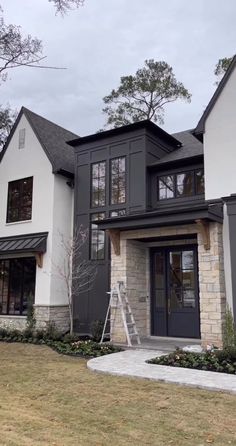 a house that has been painted gray and white with some windows on the front door