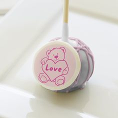 a pink and gray bear lollipop sitting on top of a white table