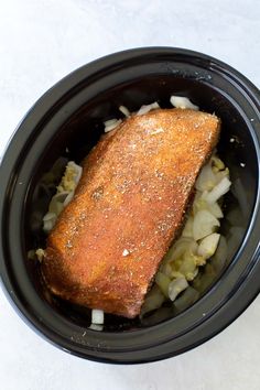 a piece of fish in a bowl with onions and seasoning