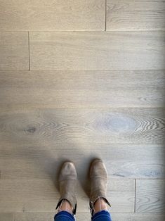 a person standing on top of a wooden floor with their feet up in the air