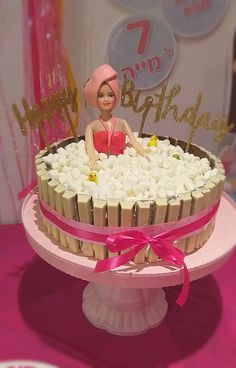 a birthday cake with a doll sitting in it