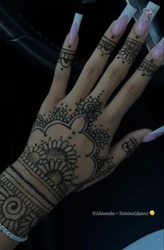 a woman's hand with henna tattoos on it