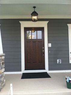 the front door of a house with two lights on each side and an entry way