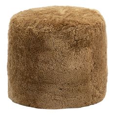 a large fluffy brown ottoman sitting on top of a white floor