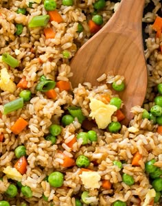 rice and peas are mixed together in a skillet with a wooden spoon on the side