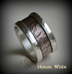 "Completely handcrafted through metalwork, in Asheville, NC. No mass production is involved. Much love and care is put into each ring. These are built to last. Width: Indicated on photos Choose between 6mm - 14mm wide Choose desired core metal for your ring Thickness: 2.5mm approximately Materials: Outer metal is .999 Fine silver Core metals are either: Copper or solid 14K Rose Gold High quality materials from the USA How to order: If you want a custom ring in this design: *Select width & me Rustic Wedding Band, Rustic Wedding Bands, Oxidized Ring, Silver Core, Engagement Band, Copper Ring, Custom Ring, Cross Ring, Wide Band Rings