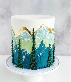 a cake decorated with trees and mountains on a plate