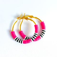 two pairs of hoop earrings with pink and black beads on white background, side by side