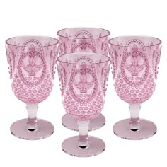 four pink glass goblets sitting on top of each other