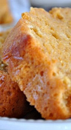 two pieces of cake sitting on top of a white plate next to another piece of bread