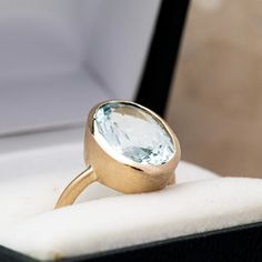 Introducing our exquisite Oval Aquamarine Gold Ring, a stunning piece of jewelry crafted from 14k Yellow Gold and a rare, high-quality aquamarine gemstone. As the birthstone for March, this eco-friendly ring is the perfect gift for any March-born loved one. The oval-shaped aquamarine stone is set in a hand-carved, rich gold setting that accentuates the gemstone's size and clarity. We've opted for a matte finish on the gold setting to allow the stone to shine even brighter. The bezel is heavy-wal Modern Oval Aquamarine Rings, Modern Aquamarine Oval Rings, Modern Oval Blue Topaz Ring, Oval Aquamarine Birthstone Ring, Oval Aquamarine Birthstone Ring Fine Jewelry, Modern Oval Topaz Birthstone Ring, Modern Blue Topaz Oval Ring, Elegant Oval Aquamarine Birthstone Ring, Aquamarine Oval Birthstone Ring