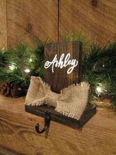 a wooden sign sitting on top of a mantle covered in pine cones and burlocks