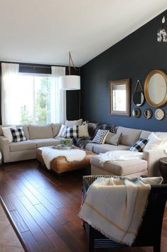 a living room filled with lots of furniture next to a large window and wooden floor