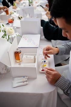 a woman sitting at a table with some bottles