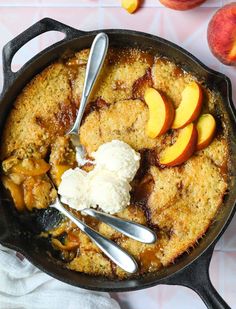 a skillet filled with peach cobbler and ice cream