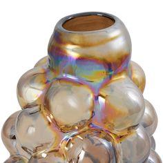 a glass vase sitting on top of a pile of other glass objects in front of a white background