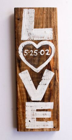 a piece of wood that has been painted with white paint and the word love on it