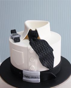 a white and black cake with a tie on it