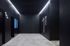 an empty room with black walls and lights