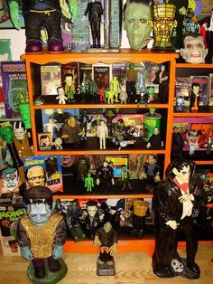 many halloween figurines are displayed on shelves