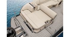 the inside of a motor boat with seats and steering wheel on the front deck, looking down at the water