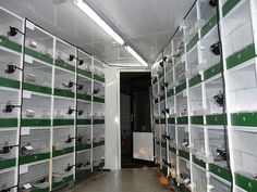 a room filled with lots of green and white shelves next to each other on either side of the wall