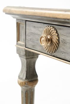 an old wooden table with gold handles and drawers on it's sides, against a white background