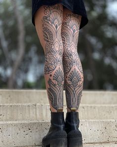 a woman with tattoos on her legs and leggings is standing on some steps