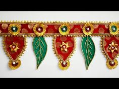 a red and green belt with gold flowers on the side, hanging from it's sides