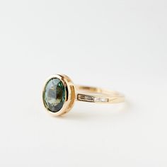 a gold ring with a green stone in the center