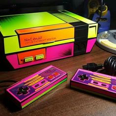 an old nintendo game console sitting on top of a wooden table next to other electronic devices