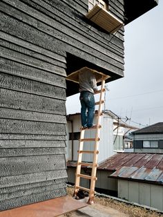 a man climbing up the side of a building on a ladder