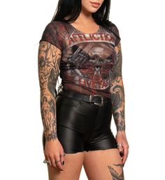 a woman with tattoos and leather shorts