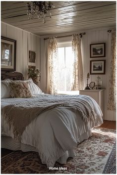 a bed sitting in a bedroom next to a window with curtains on the windowsill