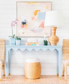 a blue table with two vases on it and a lamp in front of it