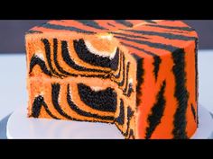 an orange and black zebra print cake on a plate