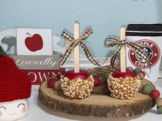 two apples are sitting on a log with candy bars in the shape of heart shaped lollipops